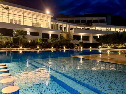 a large swimming pool in front of a building at night at The Lead Hotel in Freetown