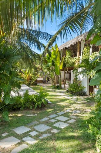 a garden with a walkway in front of a house at Pousada Pais Tropical in Icaraí