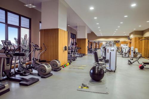 a gym with several treadmills and cardio machines at Amwaj Rotana, Jumeirah Beach - Dubai in Dubai