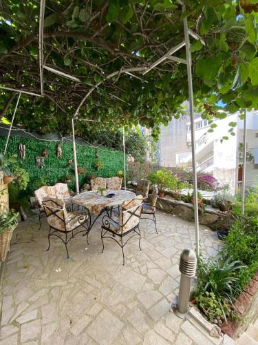 a patio with a table and chairs under a pergola at Smestaj Vella in Herceg-Novi