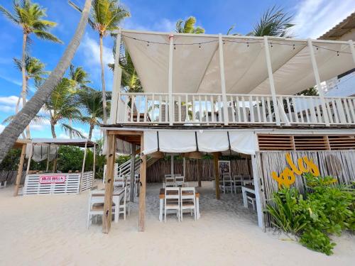 a beach house with chairs and tables on the beach at SOL CARIBE VILLAGE - STUDIOS DELUXE - playa LOS CORALES in Punta Cana