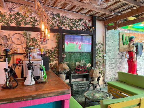 a room with a tv on a wall with a woman on a screen at SOL CARIBE VILLAGE - STUDIOS DELUXE - playa LOS CORALES in Punta Cana