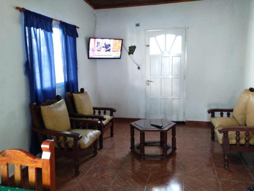 a living room with chairs and a table and a door at La LELITA in Paso de la Patria