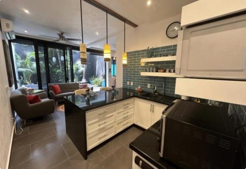 a kitchen with a counter and a living room at Casita Cobojo in Bucerías