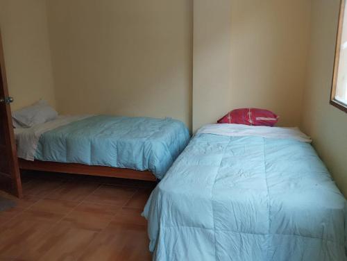 two beds in a small room with aermottermottermottermott at Glamping Machupicchu Lodge in Santa Teresa