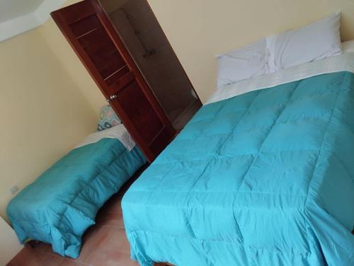 a bedroom with a bed with a blue comforter at Glamping Machupicchu Lodge in Santa Teresa