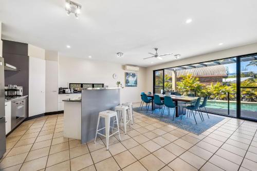 an open kitchen and dining room with a table and chairs at Tarcoola 41 in Mooloolaba
