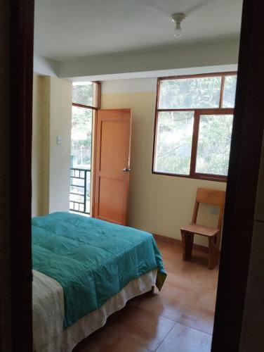a bedroom with a bed and a window and a chair at Glamping Machupicchu Lodge in Santa Teresa