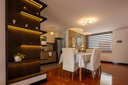 a dining room with a table and white chairs at Modern apartment - 10 Min to City Center in Cusco