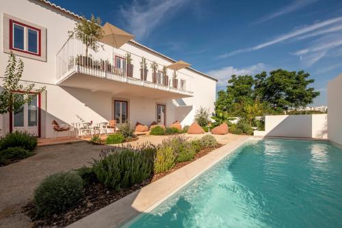 a house with a swimming pool in front of a house at Danna Portuguese Design House Porta 11 in Tavira