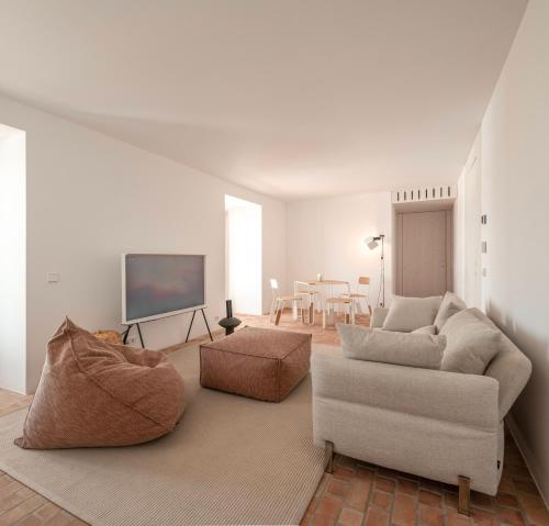 a living room with a couch and a tv at Danna Portuguese Design House Porta 11 in Tavira