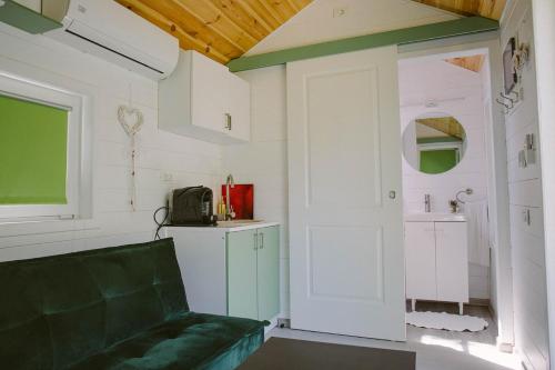 a living room with a green couch and a door at Central houses budget friendly in Bucharest