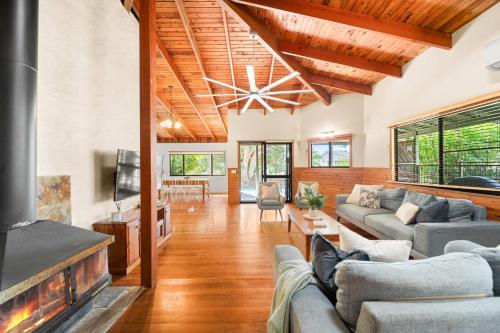 バデリムにあるBuderim Rustic Retreat - Pool & Pet Friendlyのソファと暖炉のあるリビングルーム