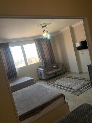 a bedroom with two beds and a couch and a window at Sneferu Pyramids View in Cairo