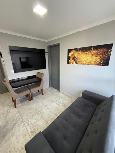 een woonkamer met een bank en een flatscreen-tv bij Confort Flat Campina Grande in Campina Grande