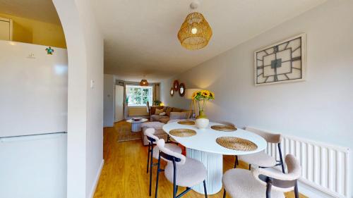 a kitchen and dining room with a white table and chairs at 3 Bedroom House with free parking and garden in London