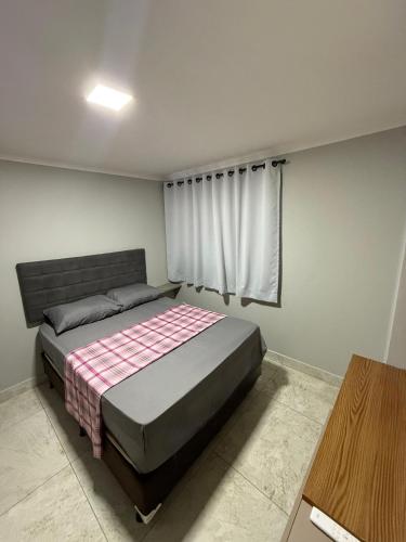 een slaapkamer met een bed en een raam erin bij Confort Flat Campina Grande in Campina Grande