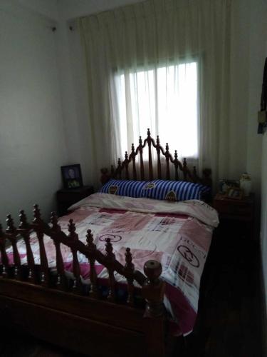 a bedroom with a wooden bed with a window at Casa Emilia 