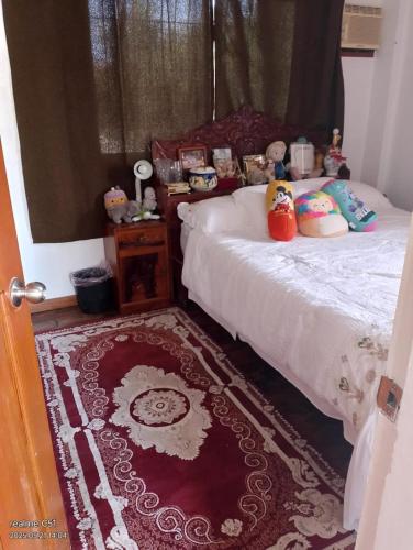 a bedroom with a bed and a red rug at Casa Emilia 