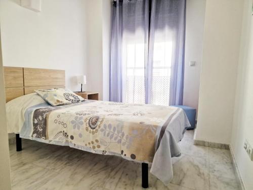 a bedroom with a bed and a window with purple curtains at APARTAMENTO MORAIRA - 3 Habitaciones in Moraira