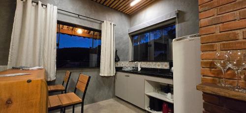 une cuisine avec une table et un mur en briques dans l'établissement Villa da Serra Studio com ar condicionado Quente/frio, à Conceição da Ibitipoca