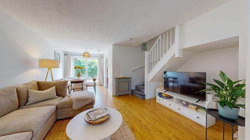 a living room with a couch and a tv at 3 Bedroom House with free parking and garden in London