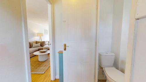 a bathroom with a toilet and a living room at 3 Bedroom House with free parking and garden in London