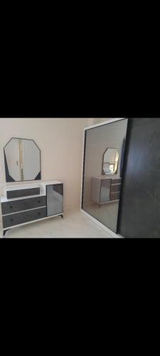 two mirrors and a dresser in front of a mirror at غرفة مفروشة للايجار in Kafr Mas‘ūd