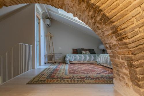 a living room with a couch and a brick wall at La Casa del Pasadizo elegante casona restaurada con piscina in Oropesa