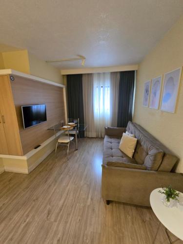 a living room with a couch and a table at Flat Ambassador in Curitiba