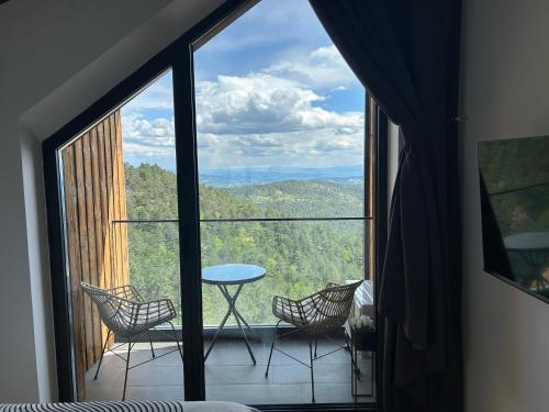 a room with a large window with chairs and a table at Divcibare Vrh 26 in Divčibare