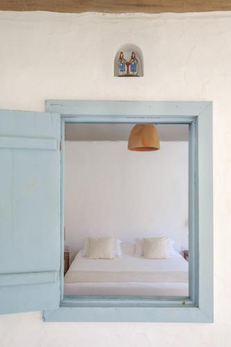 a window with a bed in a room at Vila Oyá - Praia de Algodões in Marau