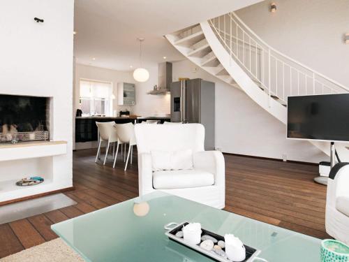a living room with a couch a table and a staircase at 4 star holiday home in Skagen in Skagen