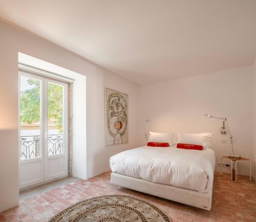 a white bedroom with a bed and a window at Danna Portuguese Design House Porta 10 in Tavira