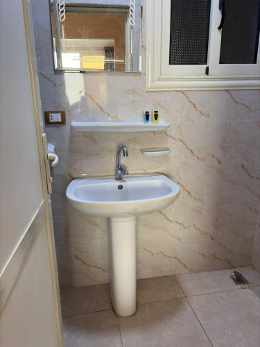 a bathroom with a white sink and a mirror at Sneferu Pyramids View in Cairo