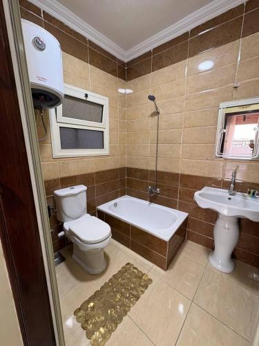 a bathroom with a toilet and a tub and a sink at Sneferu Pyramids View in Cairo