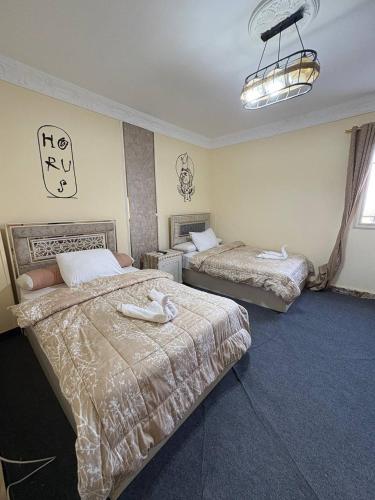 a hotel room with two beds and a chandelier at Sneferu Pyramids View in Cairo
