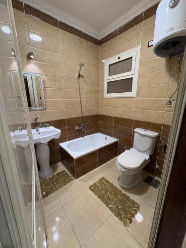 a bathroom with a toilet and a tub and a sink at Sneferu Pyramids View in Cairo