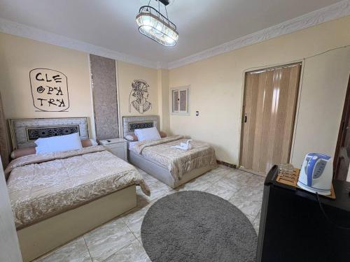 a bedroom with two beds and a tv in it at Sneferu Pyramids View in Cairo
