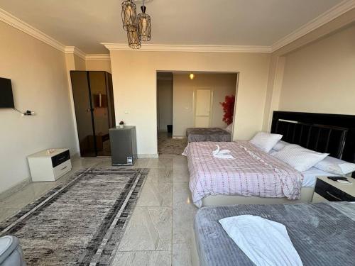 a hotel room with two beds and a television at Sneferu Pyramids View in Cairo