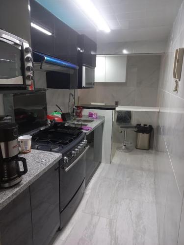 a kitchen with a stove and a counter top at Departamento cómodo tranquilo in Mexico City