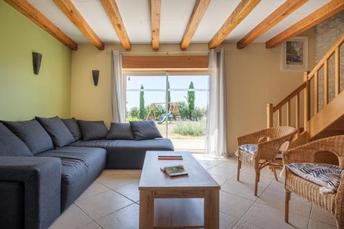a living room with a blue couch and a table at Calme et confort en Charente , Gîte Les Vignes avec piscine in Saint-Médard