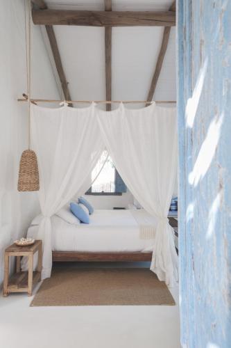 a bedroom with a bed with a mosquito net at Vila Oyá - Praia de Algodões in Marau