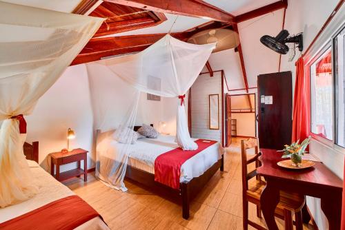 a bedroom with a bed with a mosquito net at Hotel El Encanto in Cahuita