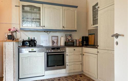 a kitchen with white cabinets and an oven at 2 Bedroom Awesome Home In Højer in Højer