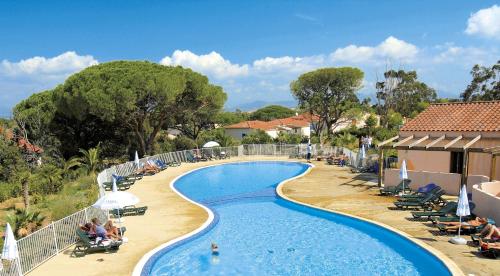 - une piscine dans un complexe avec des chaises dans l'établissement Résidence Odalys Domaine des Eucalyptus, à Saint-Aygulf