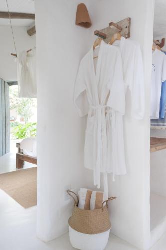 a room with white clothes hanging on a wall at Vila Oyá - Praia de Algodões in Marau