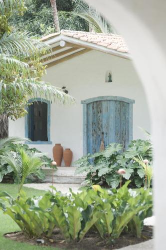 a house with a blue door and some plants at Vila Oyá - Praia de Algodões in Marau