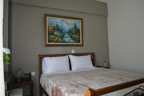 a bedroom with a bed with a painting on the wall at The Bliss Z1 in Kastoria