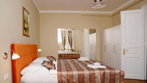 a hotel room with two beds and a mirror at Apartments & Rooms Flowers in Zagreb